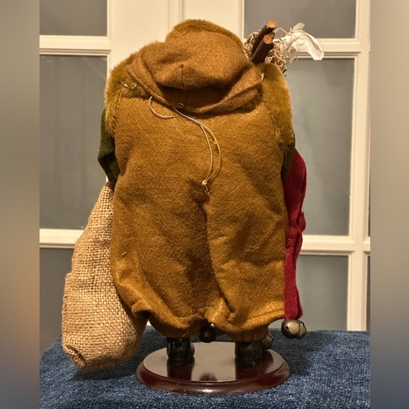 Shaggy haired and bearded Santa wears a brown cape and carries a burlap sack. - Picture 7 of 9